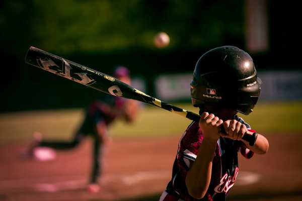 A little league batter winding up for a pitch